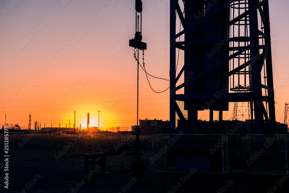Oil pumps are running in the sunset at the oil field. The outline of the pumping unit. Oil pumps are running in the sunset at the oil field. The outline of the pumping unit.