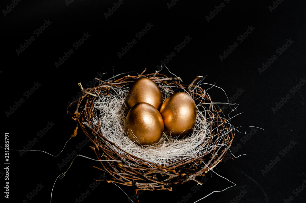 Golden Easter Eggs in birds Nest on black background. Easter Holiday concept abstract background copyspace top view several objects. Golden Easter Eggs in birds Nest on black background. Easter Holiday concept abstract background copyspace top view several objects.
