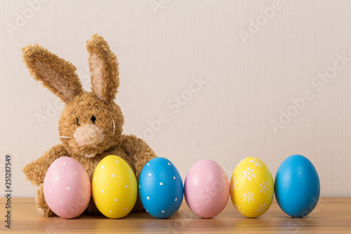Easter bunny rabbit with  painted egg on wooden background