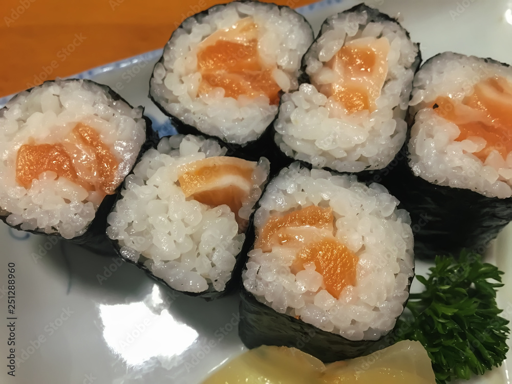 Sushi in the plate on the wood table. Sushi is a type of food preparation originating in Japan. Sushi in the plate on the wood table. Sushi is a type of food preparation originating in Japan.