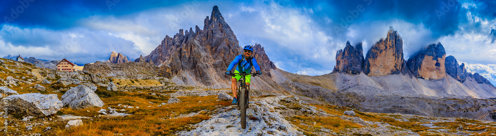 Fototapeta premium View of cyclist riding mountain bike on trail in Dolomites,Tre Cime di Laverado, South Tirol, Italy