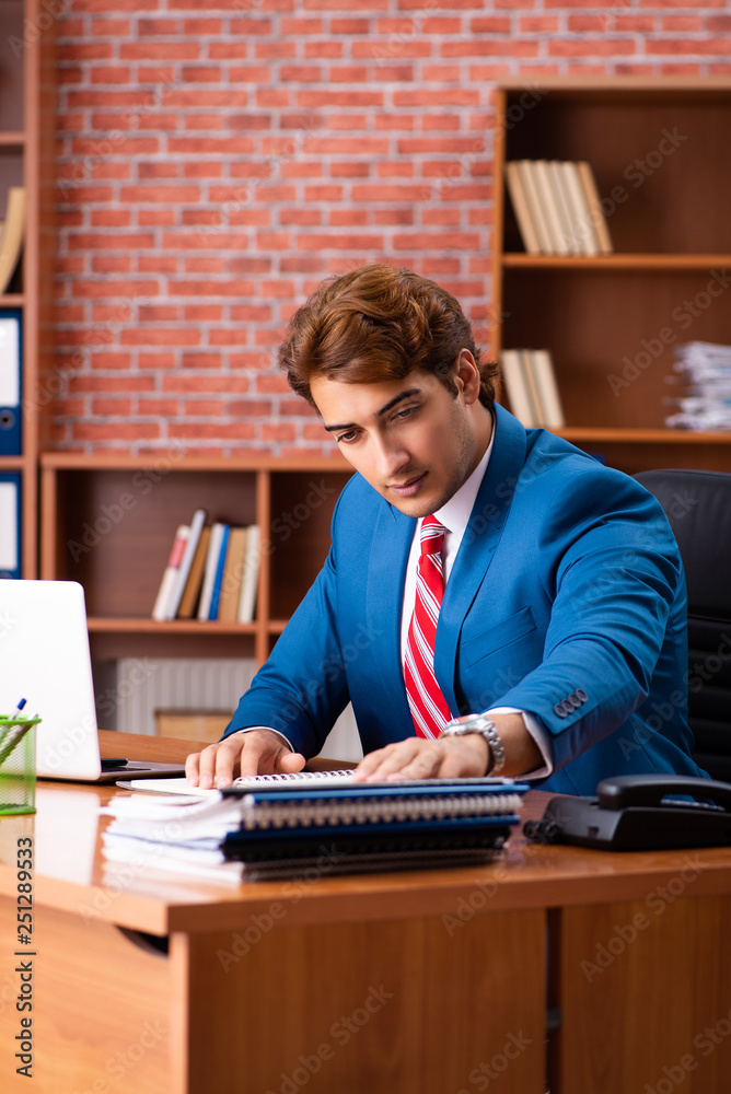 Young handsome employee sitting in the office Young handsome employee sitting in the office