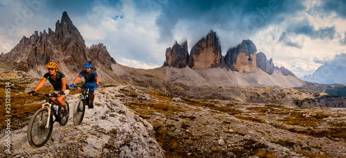 Obraz Kolarstwo kobieta i mężczyzna, jazda na rowerach w andaluzyjskich górach Dolomity. Para na rowerze enduro szlak MTB. Aktywność na świeżym powietrzu.