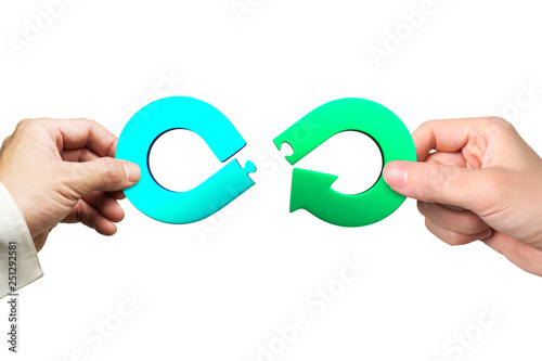 Circular economy concept. Male and female hands assembling arrow infinity recycling symbol of jigsaw puzzle pieces, isolated on white background.