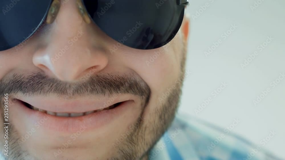 serious bearded guy in sunglasses is smiling, close up, concept human emotion serious bearded guy in sunglasses is smiling, close up, concept human emotion