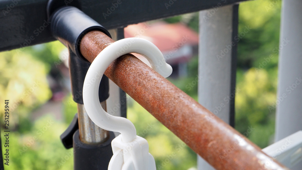 Naklejka premium white Hangers hang on rusted clothes rails.