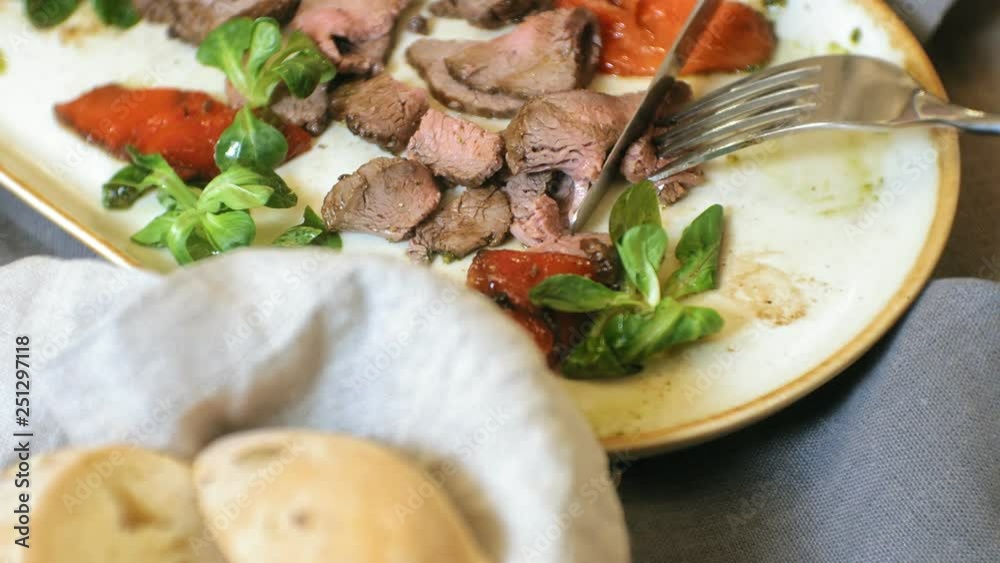 close-up shooting: a tasty meat dish on a plate, beef roast beef with sweet peppers and green salad leaves. close-up shooting: a tasty meat dish on a plate, beef roast beef with sweet peppers and green salad leaves.