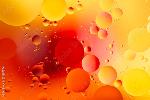 colorful oily drops in water with colorful background, close-up 