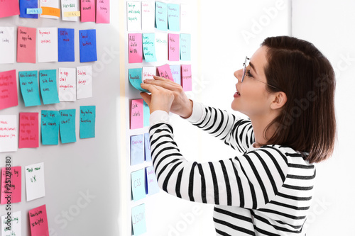 Young woman near scrum task board in office photo