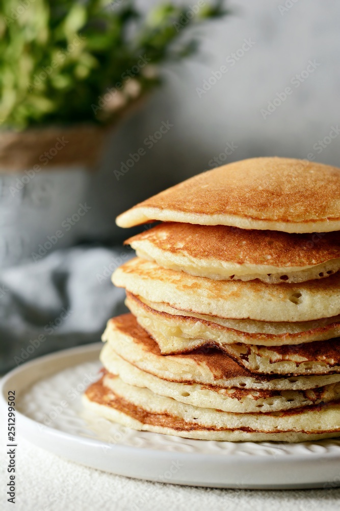 Sweet Homemade Stack of Pancakes with  honey for Breakfast  on a gray background. Sweet beautiful breakfast. Brunch. Family Breakfast. Concept for cafes, restaurants, fast food outlets, bars