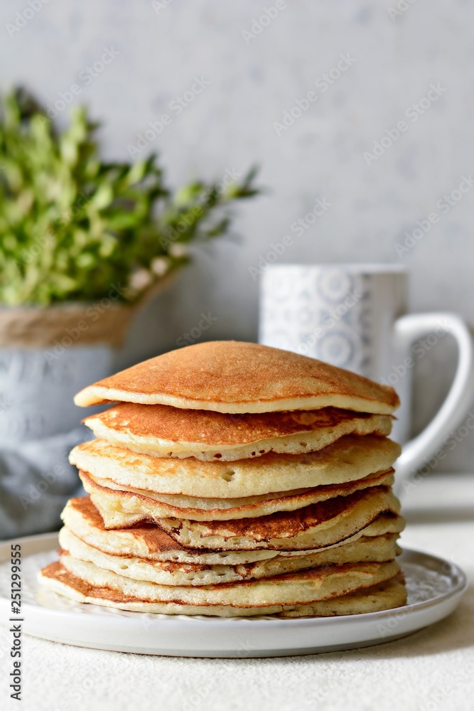 Sweet Homemade Stack of Pancakes with honey for Breakfast on a gray background. Sweet beautiful breakfast. Brunch. Family Breakfast. Concept for cafes, restaurants, fast food outlets, bars Sweet Homemade Stack of Pancakes with honey for Breakfast on a gray background. Sweet beautiful breakfast. Brunch. Family Breakfast. Concept for cafes, restaurants, fast food outlets, bars
