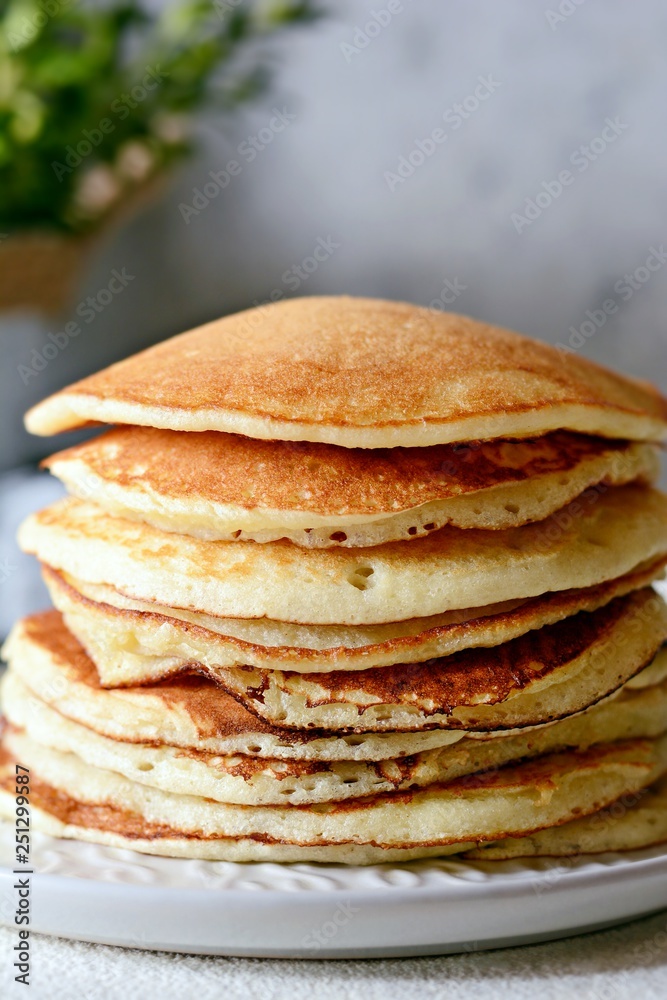 Sweet Homemade Stack of Pancakes with honey for Breakfast on a gray background. Sweet beautiful breakfast. Brunch. Family Breakfast. Concept for cafes, restaurants, fast food outlets, bars Sweet Homemade Stack of Pancakes with honey for Breakfast on a gray background. Sweet beautiful breakfast. Brunch. Family Breakfast. Concept for cafes, restaurants, fast food outlets, bars