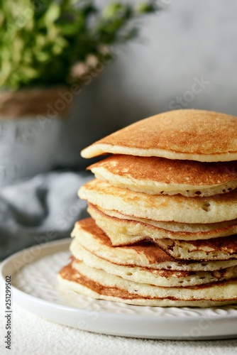 Sweet Homemade Stack of Pancakes with honey for Breakfast on a gray background. Sweet beautiful breakfast. Brunch. Family Breakfast. Concept for cafes, restaurants, fast food outlets, bars