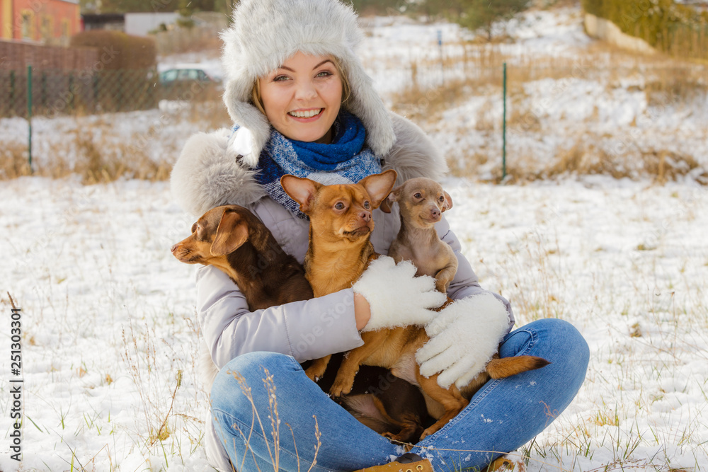 Woman playing with dogs during winter