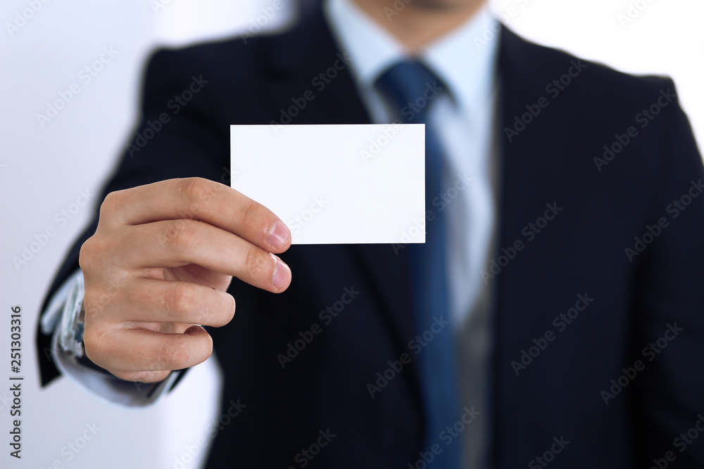 Unknown businessman hand holding business card with empty space, close-up Unknown businessman hand holding business card with empty space, close-up