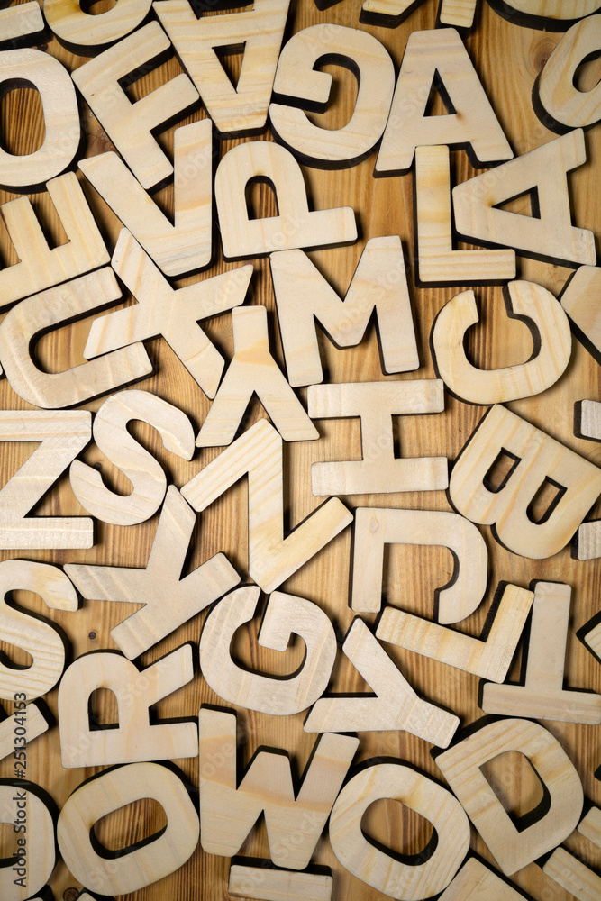 Random wooden block letters lying on wooden surface. Top view. Random wooden block letters lying on wooden surface. Top view.