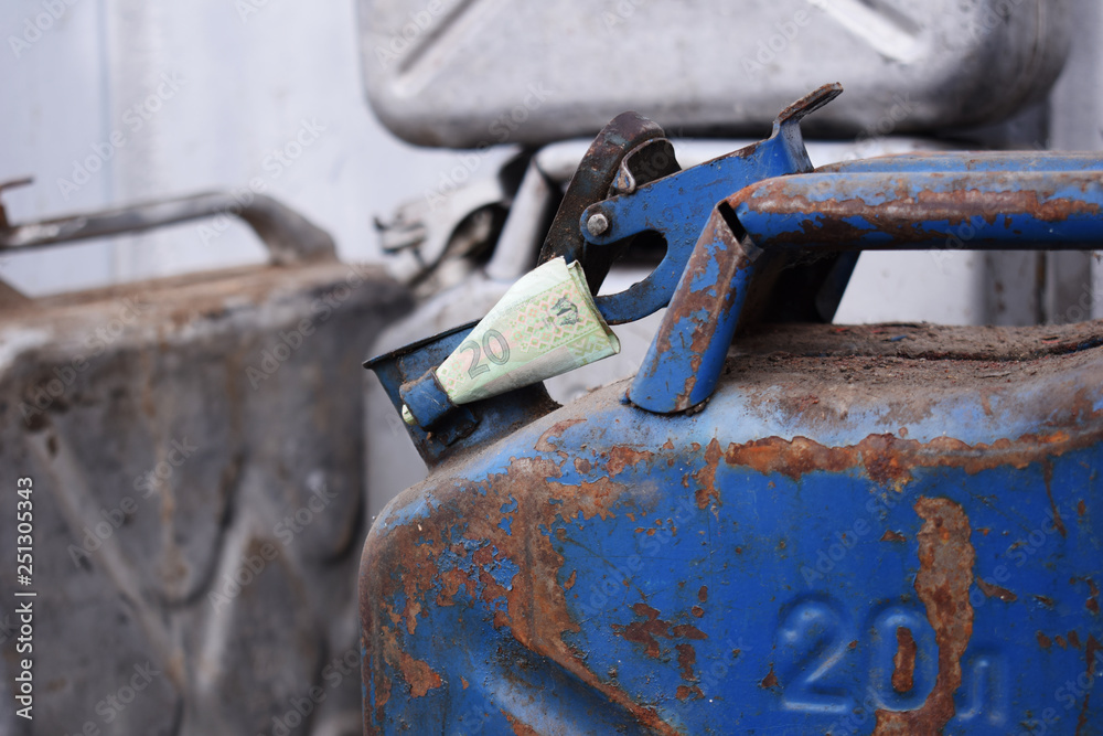Metal barrel and Ukrainian money, the concept of the cost of gasoline, diesel, gas. Refilling the car. 20 liter and banknote 20 Ukrainian hryvnia. Metal barrel and Ukrainian money, the concept of the cost of gasoline, diesel, gas. Refilling the car. 20 liter and banknote 20 Ukrainian hryvnia.