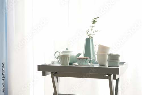 Ceramic cups with teapot on table near window © Pixel-Shot
