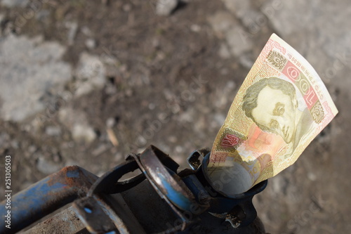 Metal barrel and Ukrainian money, the concept of the cost of gasoline, diesel, gas. Refilling the car. Banknote 100 hryvnia.