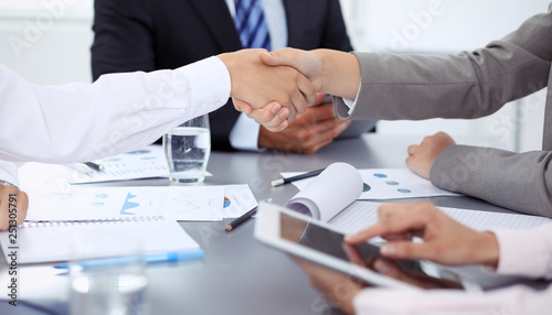 Business People shaking hands, finishing up a meeting in office, unknown human group