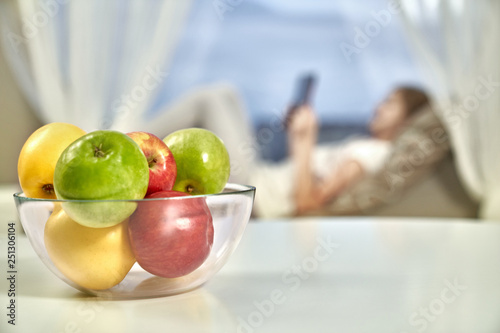 Glass bowl of fresh apples on table in new apartment.