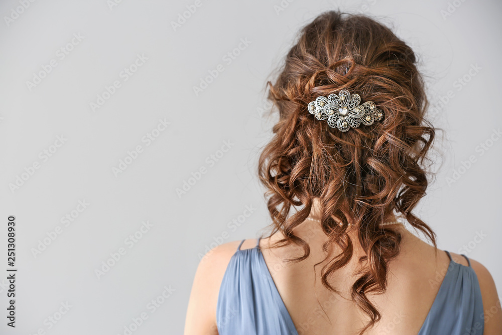 Naklejka premium Young woman with beautiful jewelry on light background