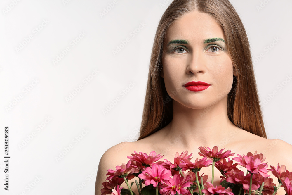 Beautiful woman with unusual makeup and flowers on white background Beautiful woman with unusual makeup and flowers on white background