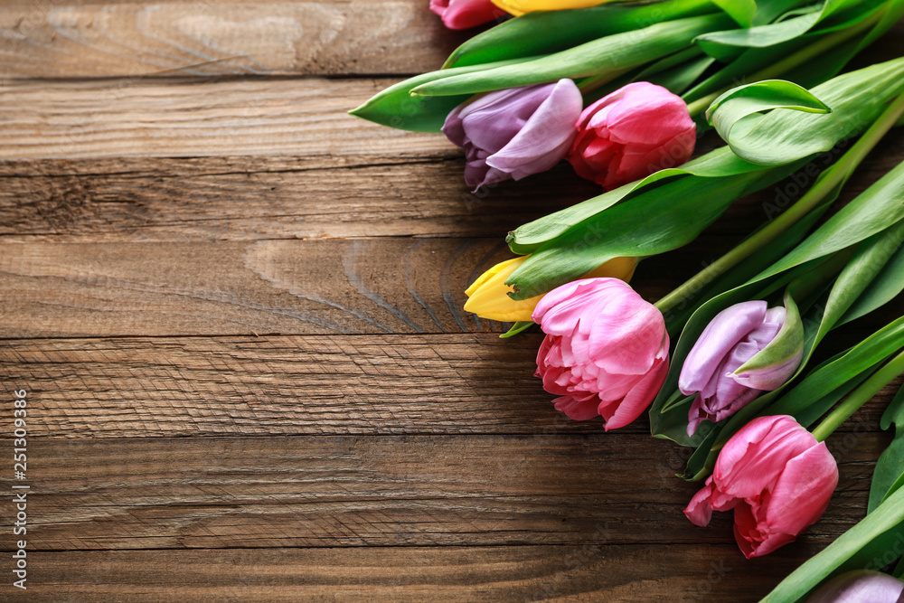 Beautiful fresh tulips on wooden background Beautiful fresh tulips on wooden background