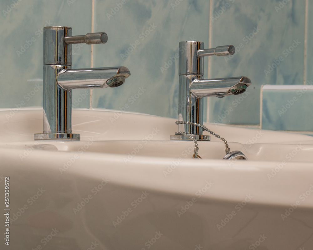 Close up of sink and two metal taps Close up of sink and two metal taps