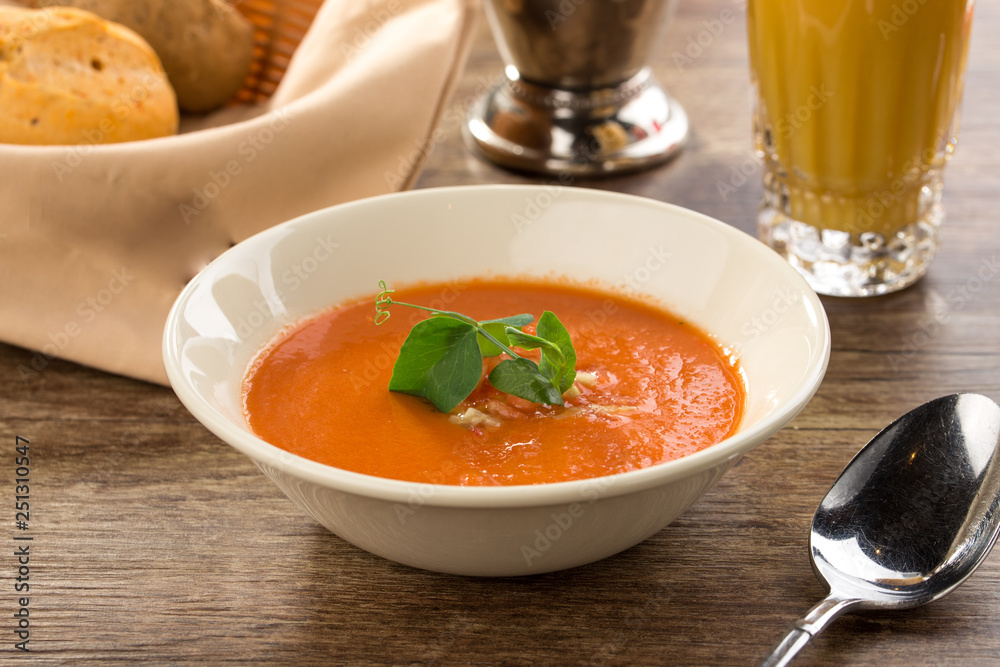 Pumpkin cream soup with glass of juice on a wooden table Pumpkin cream soup with glass of juice on a wooden table