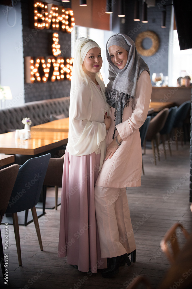 Fototapeta premium Two young muslim women standing in the cafe