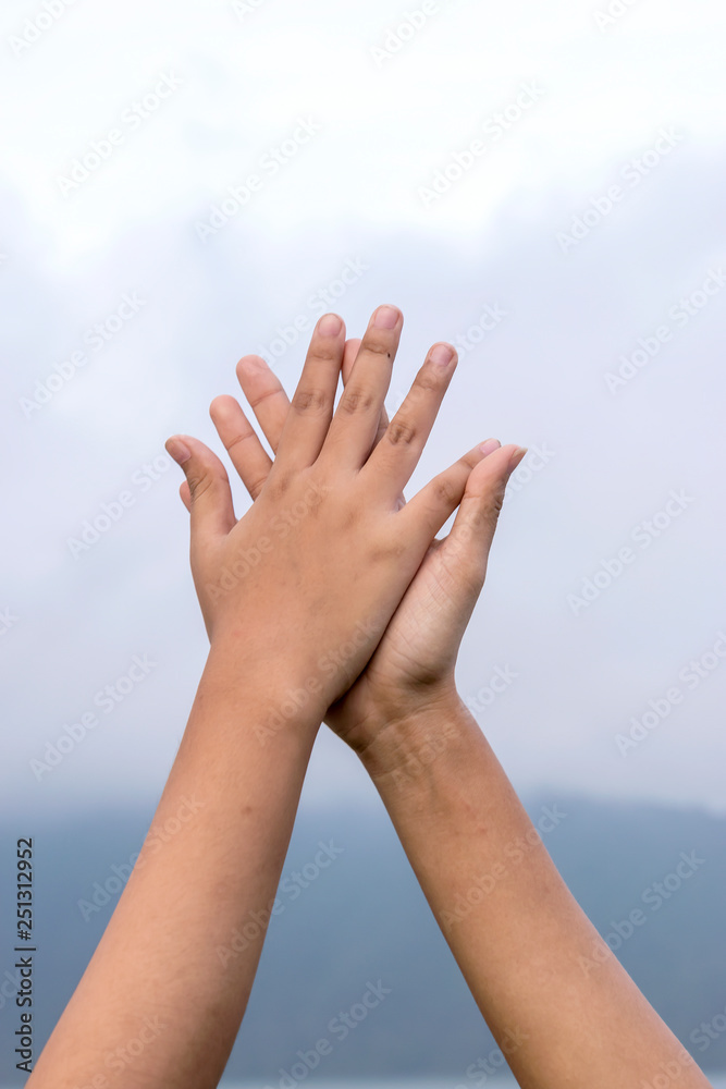 Two hands of Asian female people making hi-five gesture Two hands of Asian female people making hi-five gesture