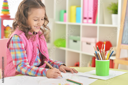 Portrait of cute beautiful smiling girl drawing at home