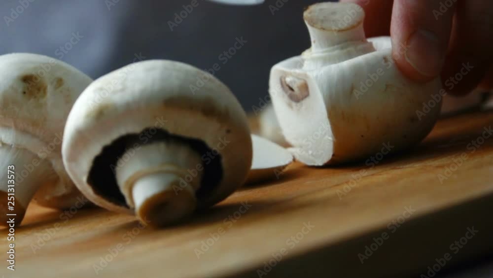 Shot of woman chef cutting mushrooms on chopping wooden board. Slow motion video Shot of woman chef cutting mushrooms on chopping wooden board. Slow motion video