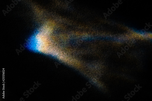 abstract light glow, lens flare, caustics water glas reflections.  light through a prism. black background. 