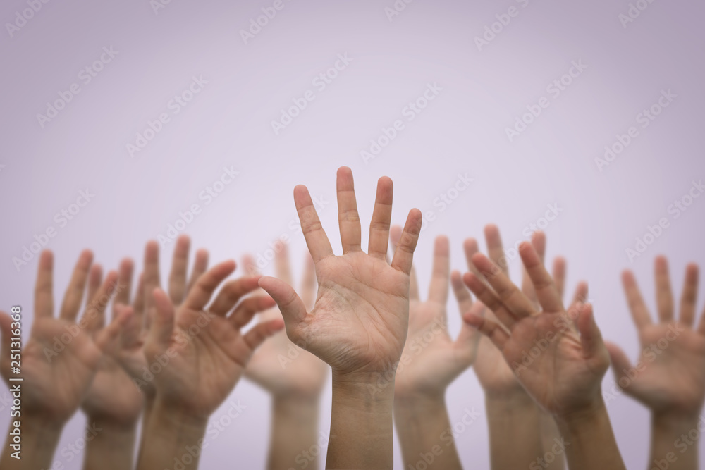 Group of human hands raised high up on pink
