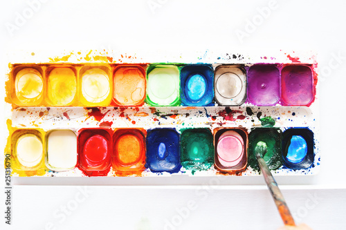watercolor palette, the child draws with paints