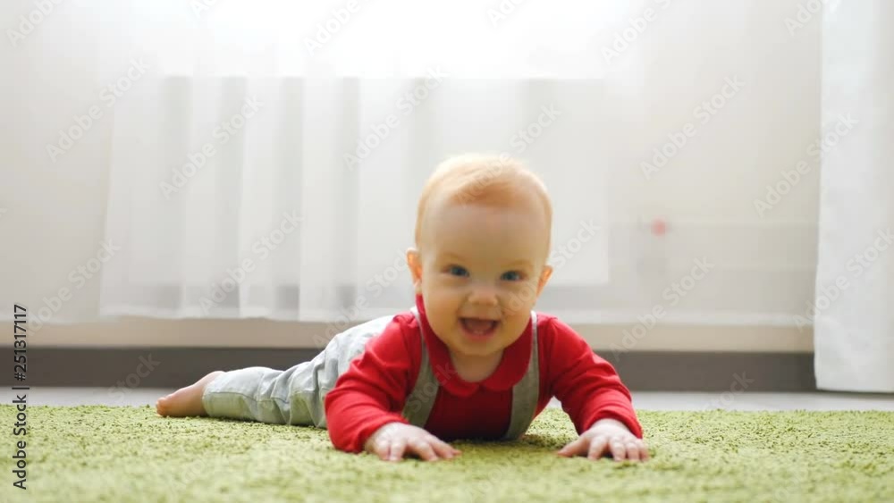 Baby Crawls Toward Rack Focus Low Angle Slow Motion. Baby crawls toward the camera in slow motion smiling and laughing in a white room Baby Crawls Toward Rack Focus Low Angle Slow Motion. Baby crawls toward the camera in slow motion smiling and laughing in a white room
