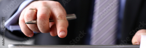 Businessman arm in suit and tie use silver pen and pad pc