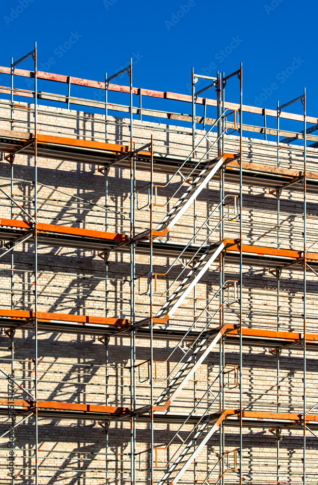 construction scaffolding with stairway upwards on blue sky background with copy space