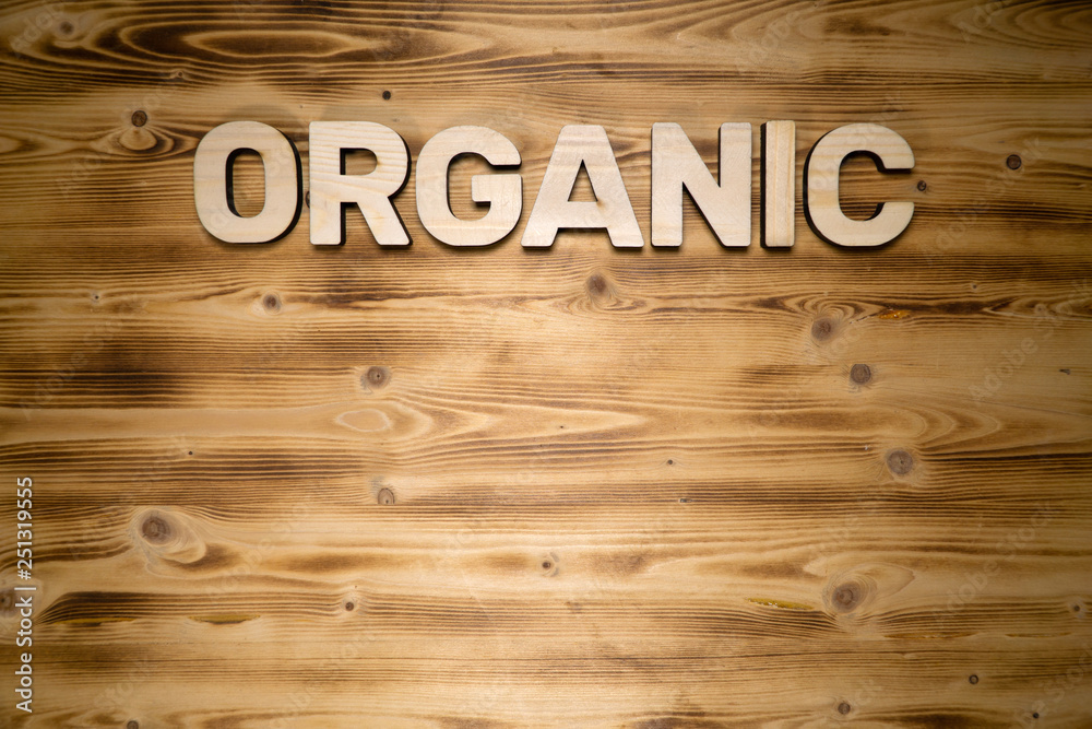 ORGANIC word made of wooden block letters on wooden board.