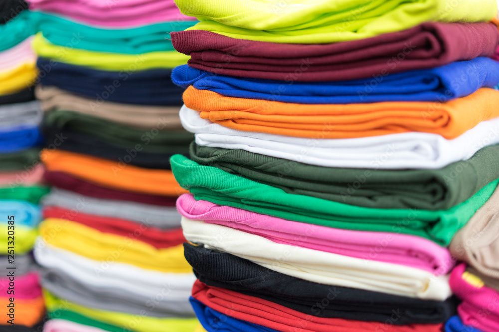 Stack T-shirts on shelf in a shop Stack T-shirts on shelf in a shop