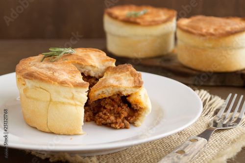 Australian meat pie on wooden table close-up with copy space, rustic style