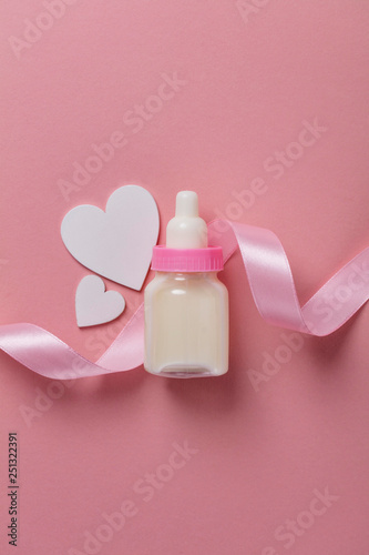 Baby bottle on a pastel pink background. New baby arrival © ink drop