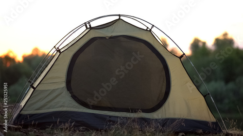 Khaki colored family tent set up in campsite, tourist equipment for camping