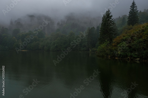 Misty hills over lake.