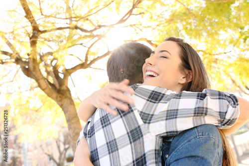 Fotografi Happy couple or friends hugging in a park