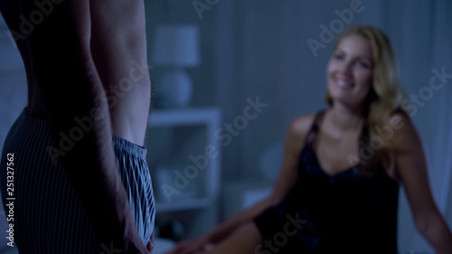 Man in underpants, sexy female smiling on background, healthy sexual life
