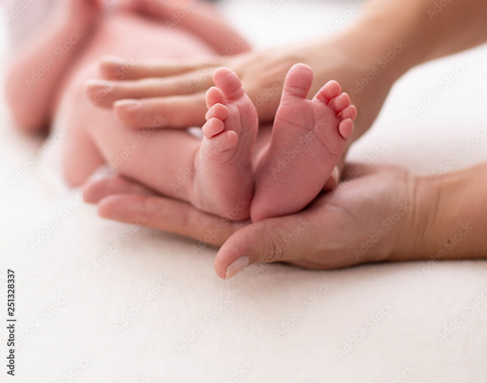 Baby feet cupped into mothers hands. Gentle blurred background of the feet and heels of a newborn Baby feet cupped into mothers hands. Gentle blurred background of the feet and heels of a newborn