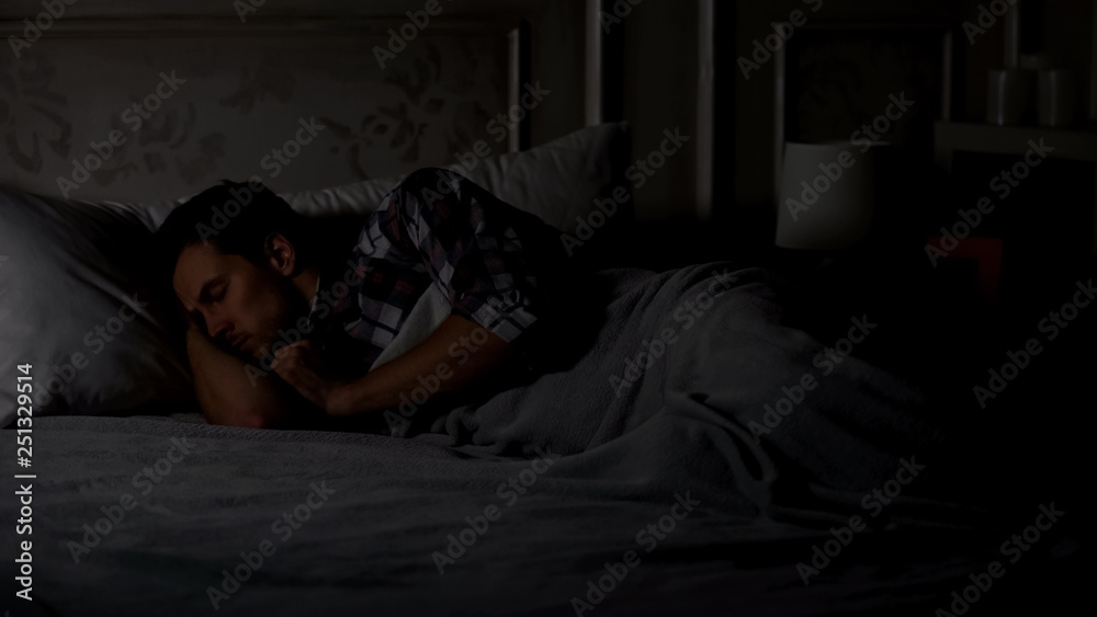 Man sleeping at night, soothing pills for good sleep, having bad dream, disorder Man sleeping at night, soothing pills for good sleep, having bad dream, disorder